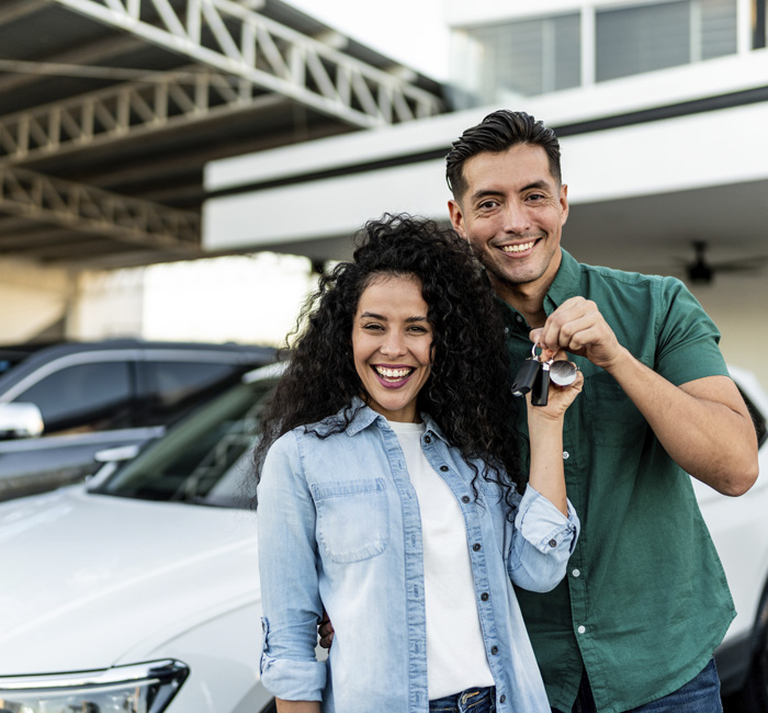 Pareja recibiendo las llaves de su auto nuevo
